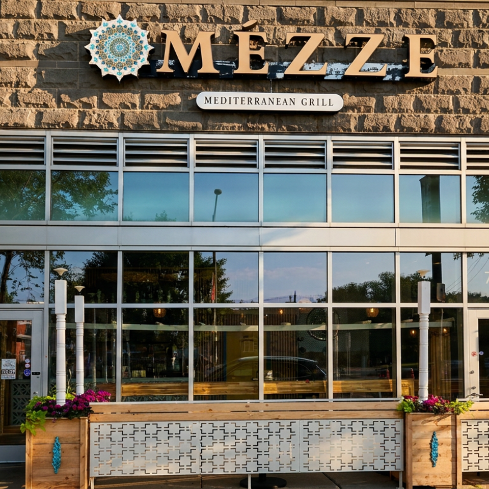 Exterior of Mezze Mediterranean Grill, a restaurant with large windows and outdoor planters.